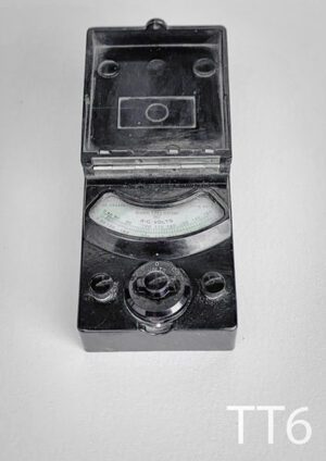 TT6-Qty-1. Dark brown fold up volt meter with gauge, dial, and 2 knobs for wire attachment. 3 1/4"W x 5" deep